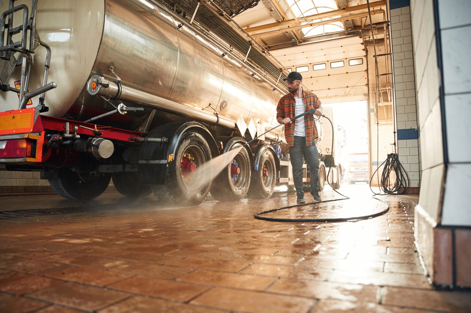 Close-up of a mechanic's hands covered in grease while working on engine parts in a workshop.